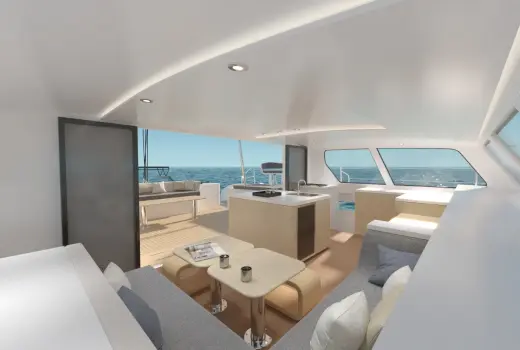 Catamaran saloon: L-shaped couch in corner, central stove/table island, modern design, ample natural light.